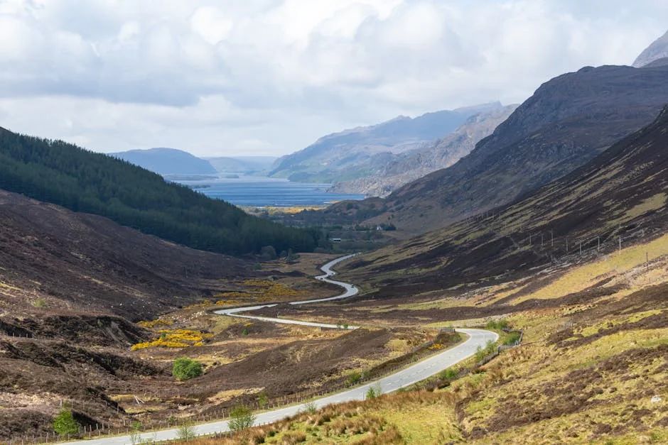 Beautiful winding road through the Highland Council landscape, showcasing nature's beauty in Scotland. - best driving roads in the united kingdom