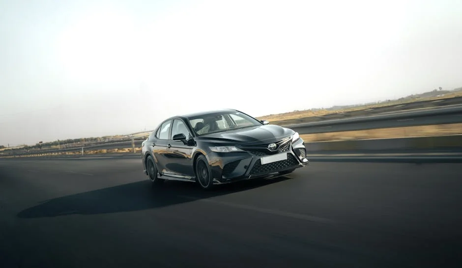 A sleek Toyota Camry in motion on a highway, capturing the essence of speed and style. - best fuel efficient cars for long commutes
