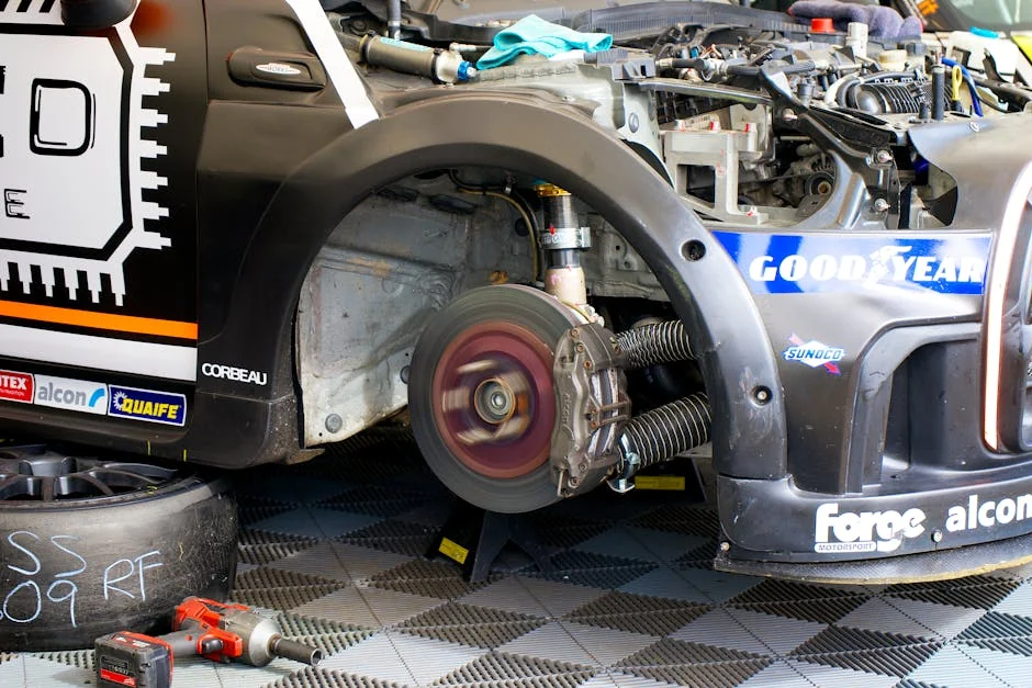 Close-up of race car undergoing maintenance in Silverstone, showing disc brake and tools. - brake pad replacement cost guide