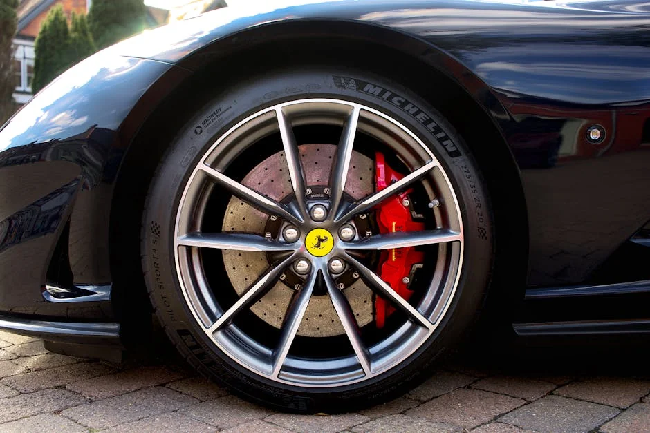 Detailed image of a Ferrari sports car wheel with red brake caliper, shot outdoors. - brake pad replacement cost guide