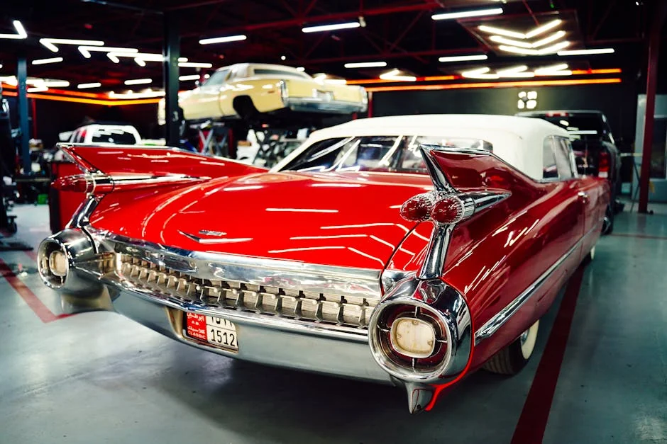 Vintage red Cadillac parked in a sleek, modern garage setting with visible license plate details. - classic car restoration tips for amateurs