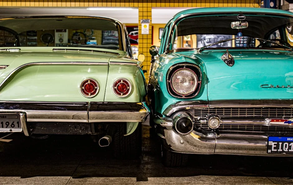 Two vintage Chevrolet cars parked in a retro garage, showcasing their classic design and chrome details. - classic car restoration tips for amateurs