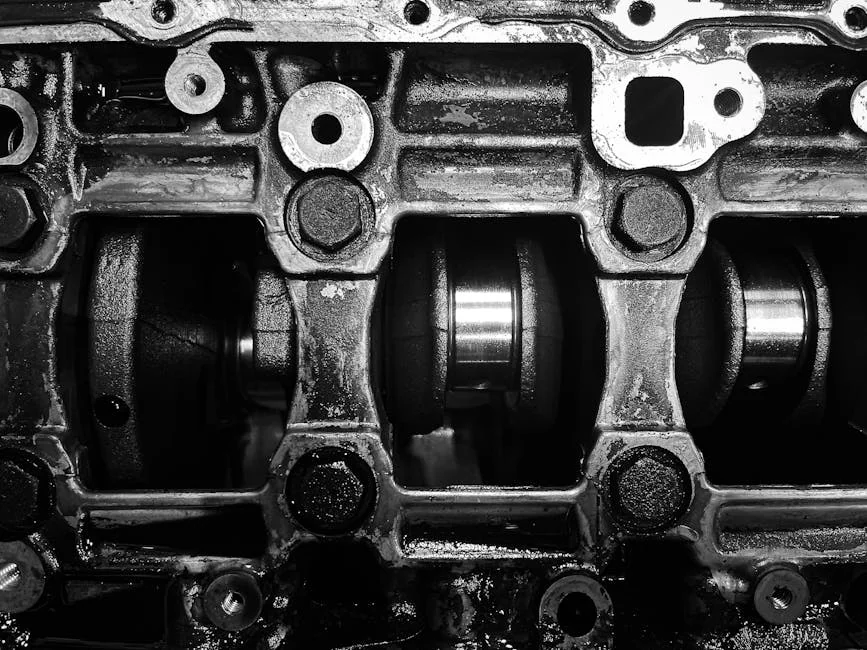 Detailed black and white close-up of a metal engine crankshaft mechanism. - signs of a failing head gasket