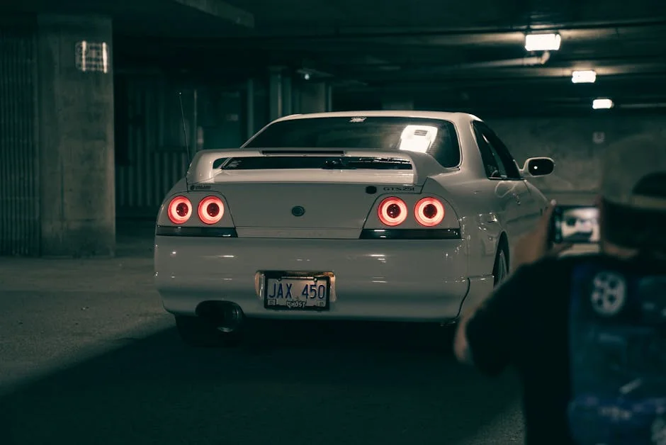 A classic white sports car with red taillights parked in a dimly lit underground garage. - underrated jdm cars under 10k