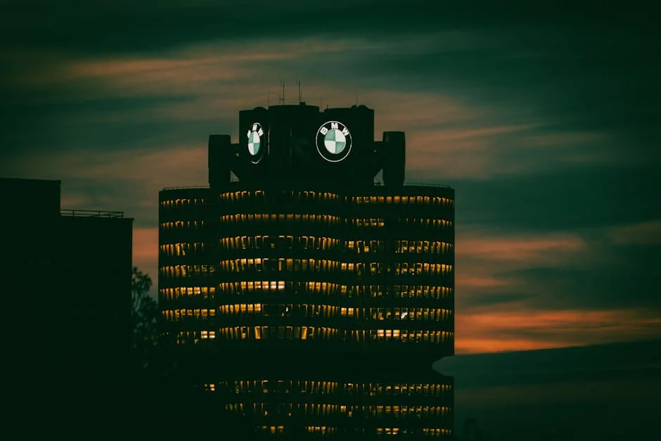 Dramatic view of BMW headquarters illuminated against the night sky in Munich, Germany. - is it worth buying a high mileage bmw